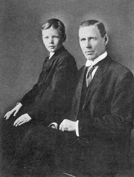 Lindbergh as a boy sits in a formal pose with his father.